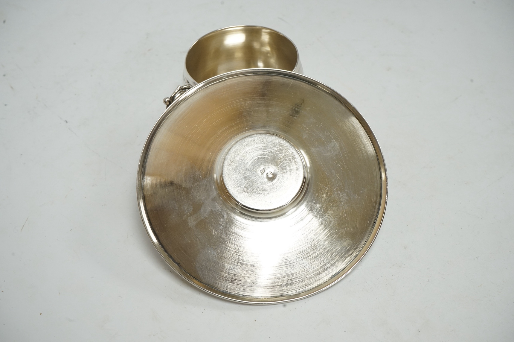 A late 19th/early 20th century French 950 standard white metal tea cup and saucer, with engraved scroll decoration, maker MS, saucer diameter 12.6cm, 3.8oz. Condition - fair to good
